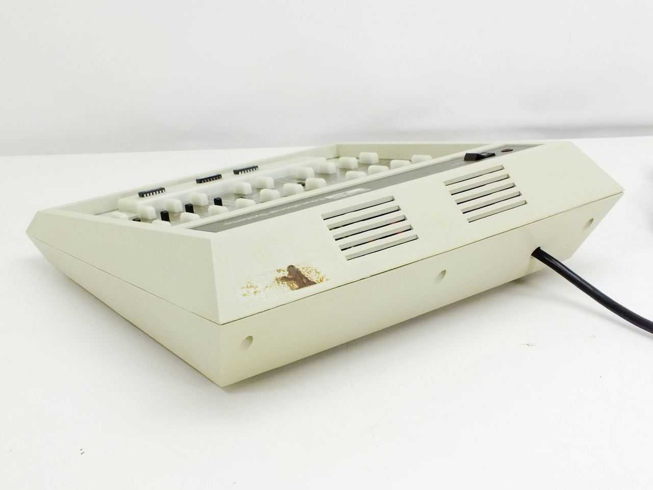 Figure 4 — A grey Heathkit/Zenith Educational Systems ET-3200 seen from the side, with a piece broken out of the cabinet bottom near a lower corner, the kind of damage years on laboratory benches produce. The…