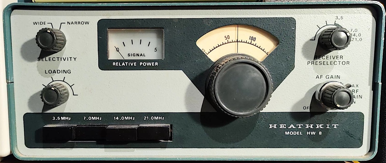 Figure 6 — An HW-8 QRP transceiver. The four band switches along the bottom, the relative-power meter and the single large tuning knob are the whole of its front panel; the receiver is direct-conversion and t…