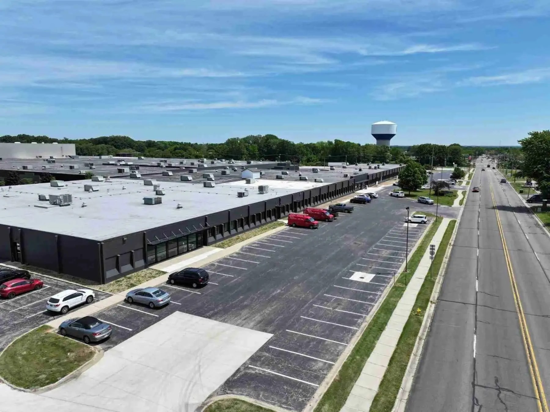 Figure 1 — The former Heath plant at 211 Hilltop Road, St. Joseph, Michigan, in 2026: now the Hilltop Business Center, repainted dark grey and shared by an automation firm, a community foundation and a childr…