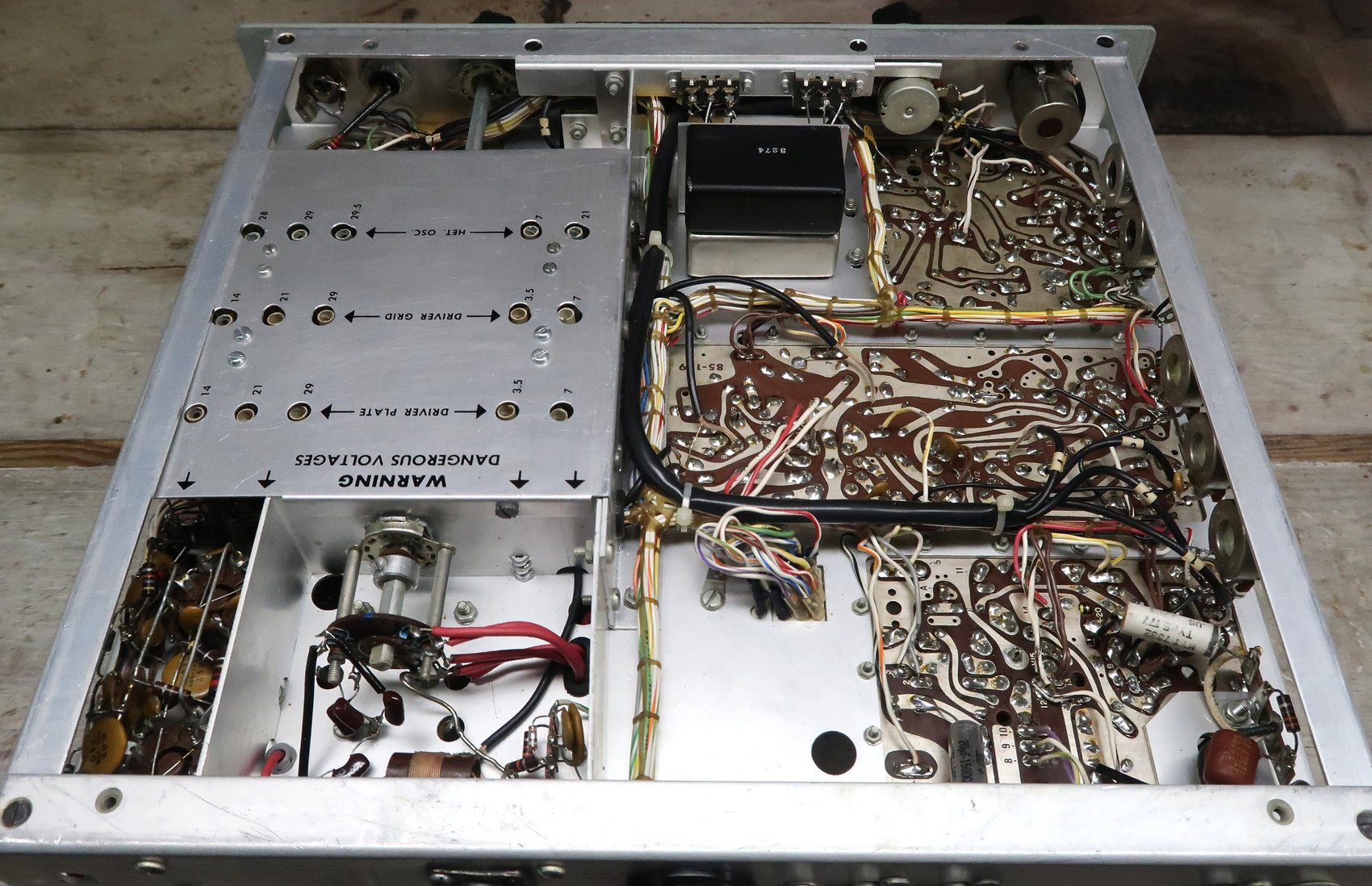 Figure 13 — The underside of a well-built and cleaned HW-101. The harness runs are the giveaway: Heath's loom dictates where most wiring goes, so a chassis that looks chaotic underneath has usually been worked…